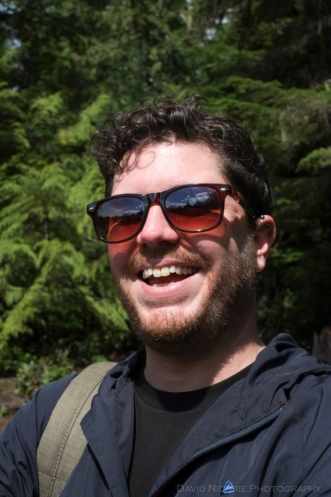 A smiling, laughing man is seen in portrait.