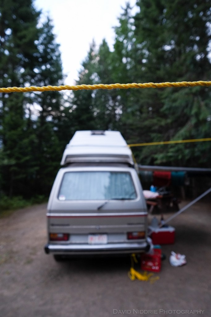 A clothes line is set up beside a Volkswagen Westfalia.