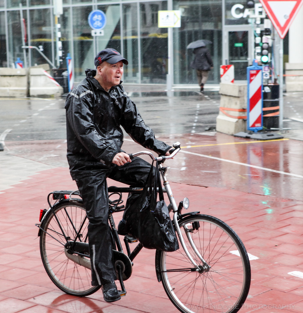 A man cycling in the rain in Utrecht, Netherlands.