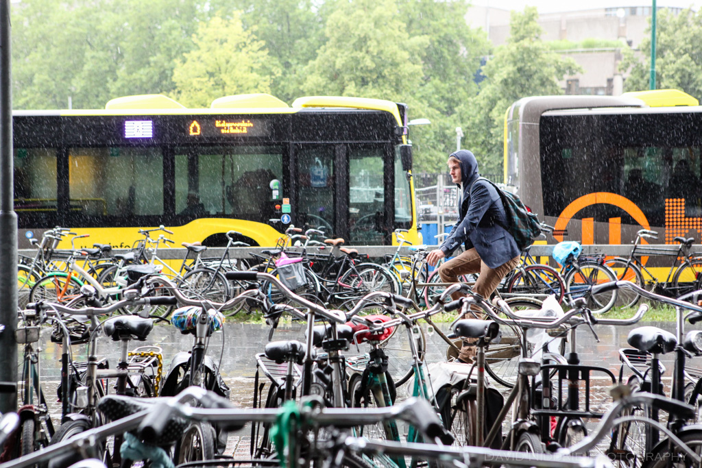 A man cycles in the rain in Utrecht, Netherlands.