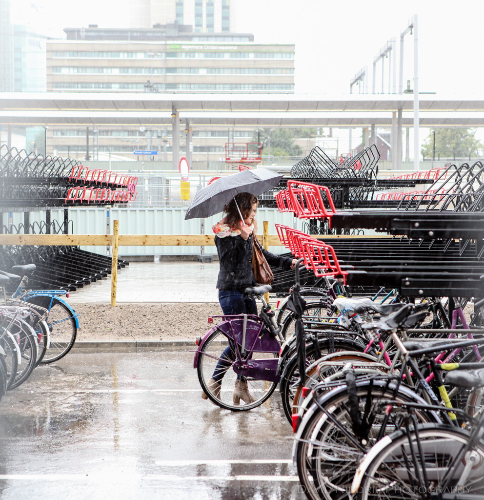 A woman parks her bicycle in the rain in Utrecht, Netherlands.