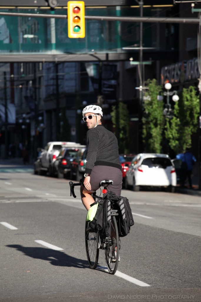 A man rides on a Vancouver street with Two Wheel Gear bicycle pannier.