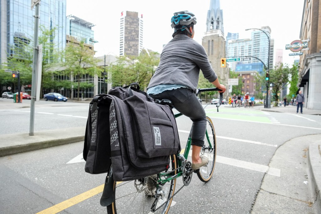 A woman poses on a Vancouver street with Two Wheel Gear bicycle pannier.