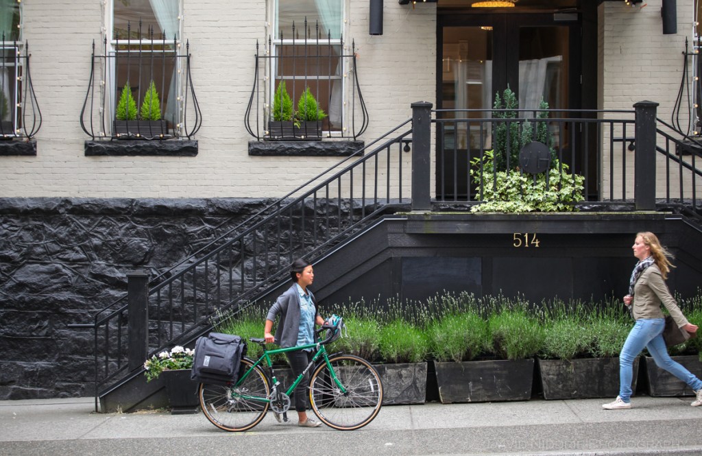 A woman poses on a Vancouver street with Two Wheel Gear bicycle pannier.