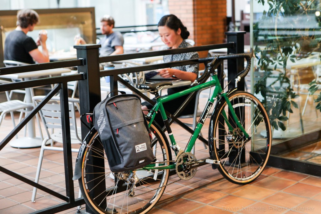 A woman poses on a Vancouver street with Two Wheel Gear bicycle pannier.